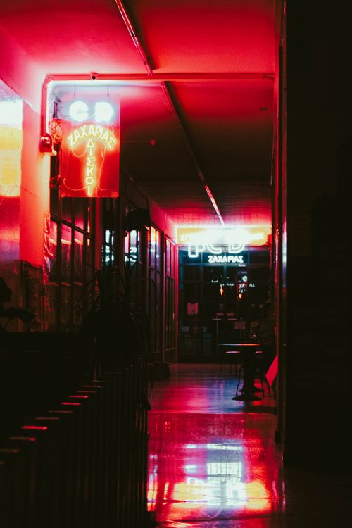 Free A dimly lit corridor featuring vibrant red neon lights and reflections, evoking a modern and retro ambiance. Stock Photo