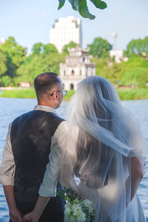 Back View of Newlyweds Standing by River