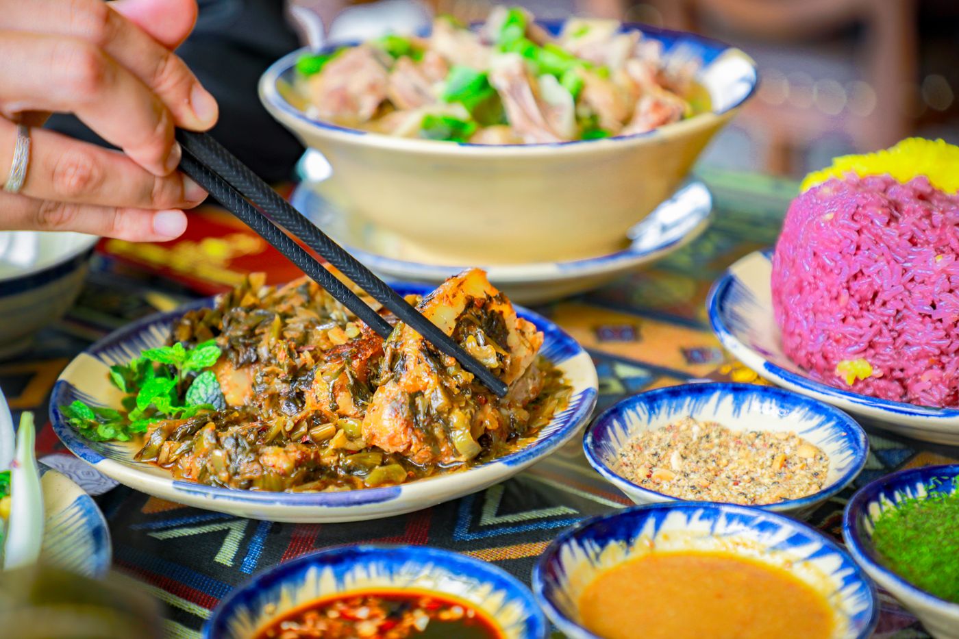 A vibrant Vietnamese meal featuring traditional dishes and chopsticks in an authentic setting.