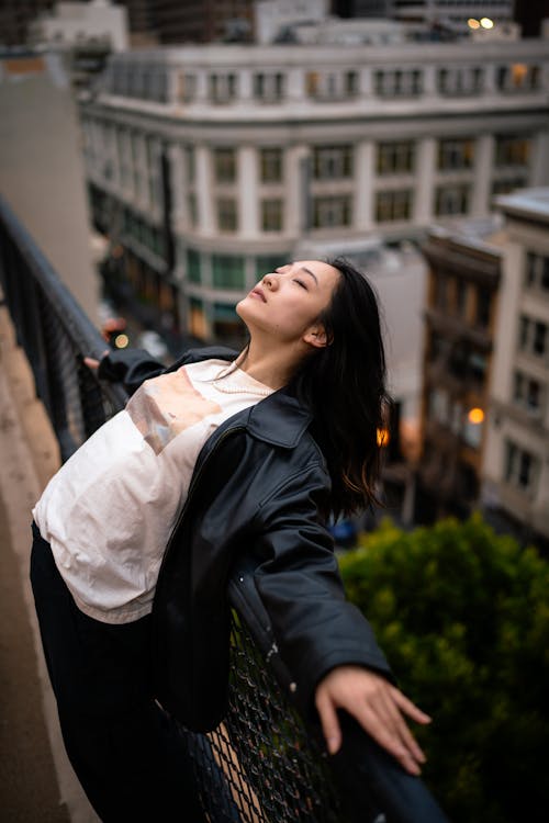 Woman in Black Jacket Leaning on Railing