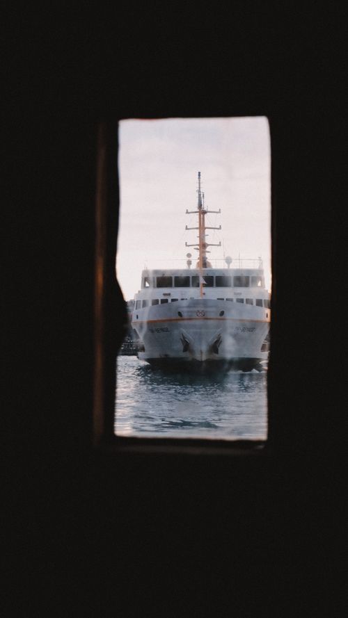 Free A cruise ship in open waters seen through a window, creating a serene nautical atmosphere. Stock Photo