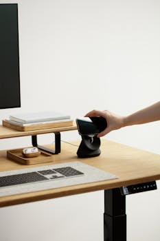 Minimalist workspace featuring a wireless charging station on an adjustable desk.