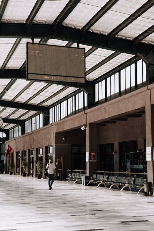 Free Traveler walking inside the spacious Ankara train station, showcasing architecture and transport atmosphere. Stock Photo