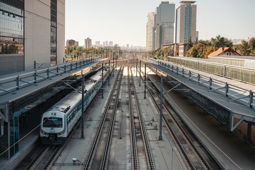 Free A bustling railway station in Ankara with trains, tracks, and towering skyscrapers. Stock Photo