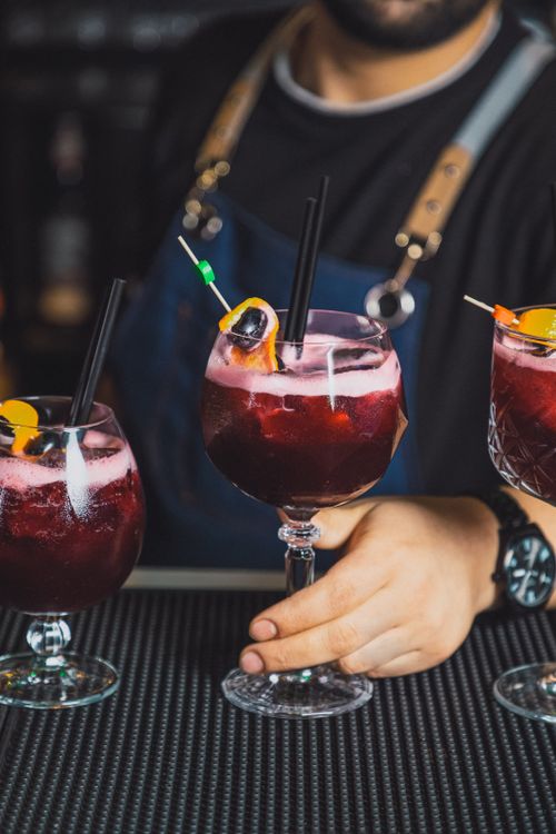Free Professional bartender preparing vibrant cocktails in a stylish bar setting. Stock Photo