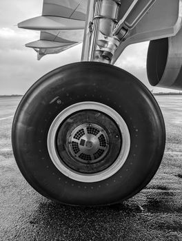 Black and white photo of an airplane wheel on a wet runway in Sylt, Germany.