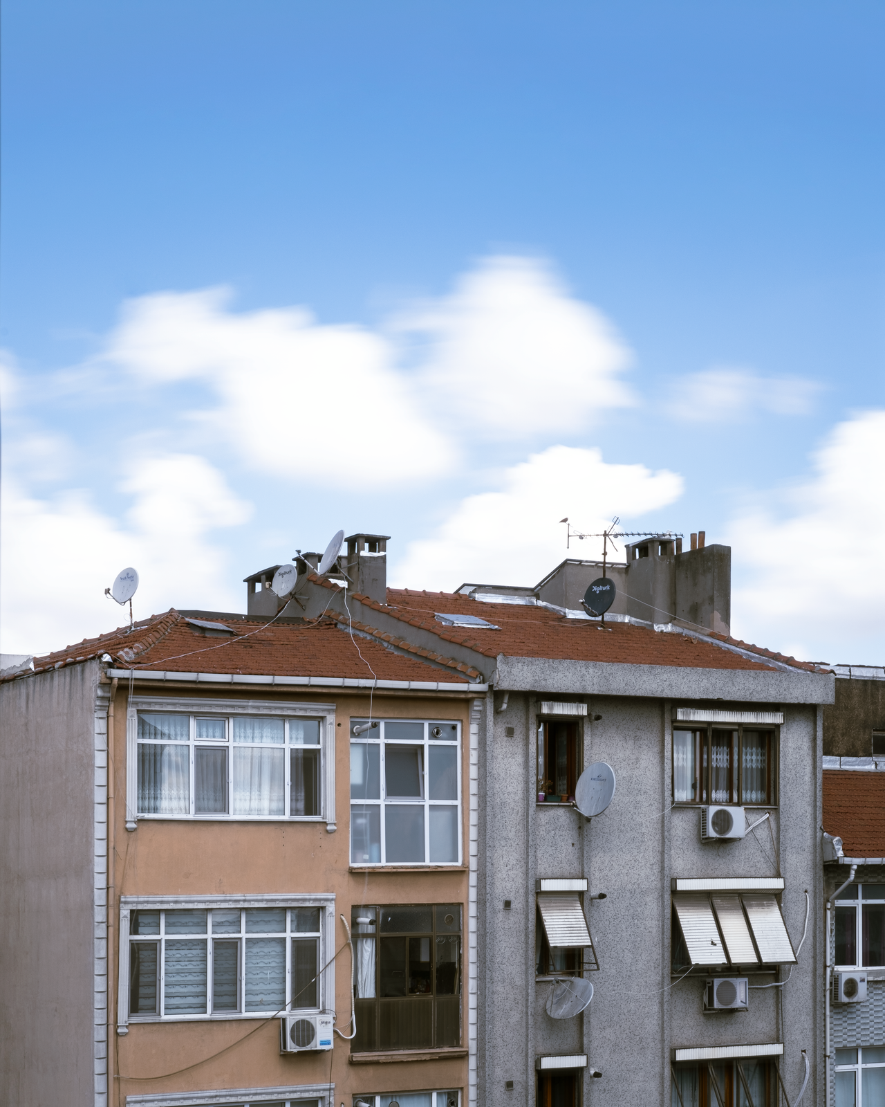 City apartment buildings with tiled roofs and rooftop equipment