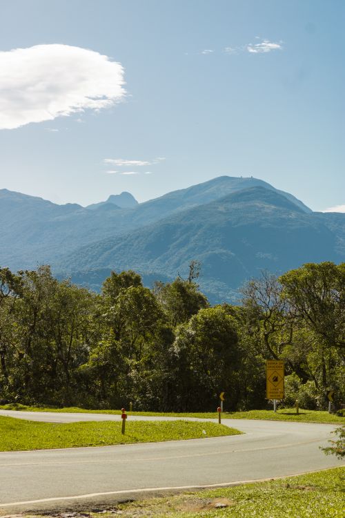 Free Curving road amidst lush greenery and mountains, perfect for nature travel inspiration. Stock Photo