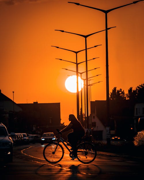 Silhouette of Man Riding a Bike During Sunset 