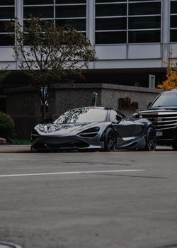Stylish black sports car parked in a bustling city street, showcasing luxury and modern design.