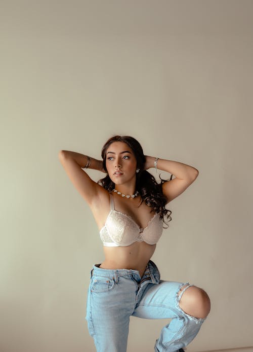 Young caucasian woman posing in blue bra and jeans stock photo