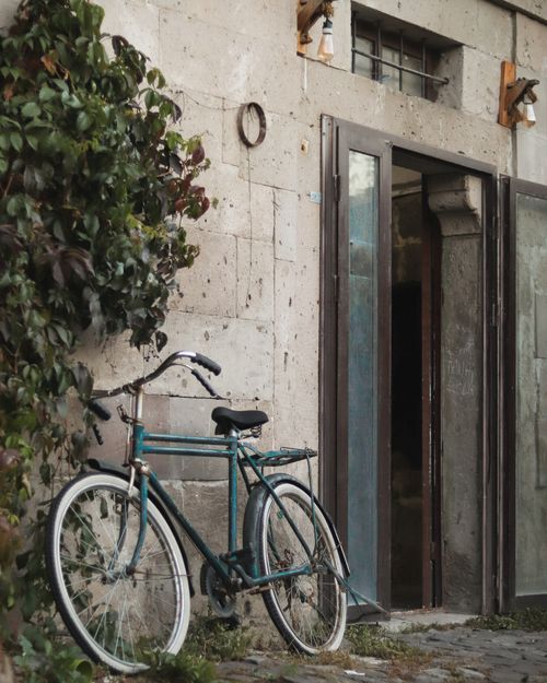 Free A vintage bicycle rests by a stone entrance in Talas, Kayseri, Turkey, showcasing urban charm. Stock Photo