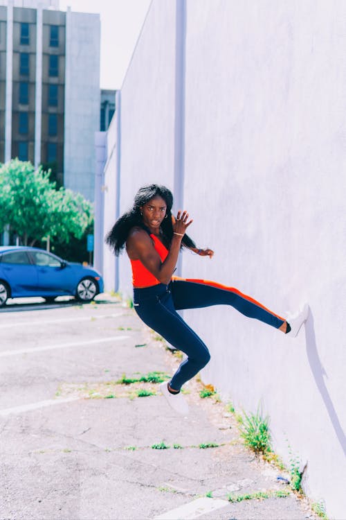 壁から飛び降りる運動女性