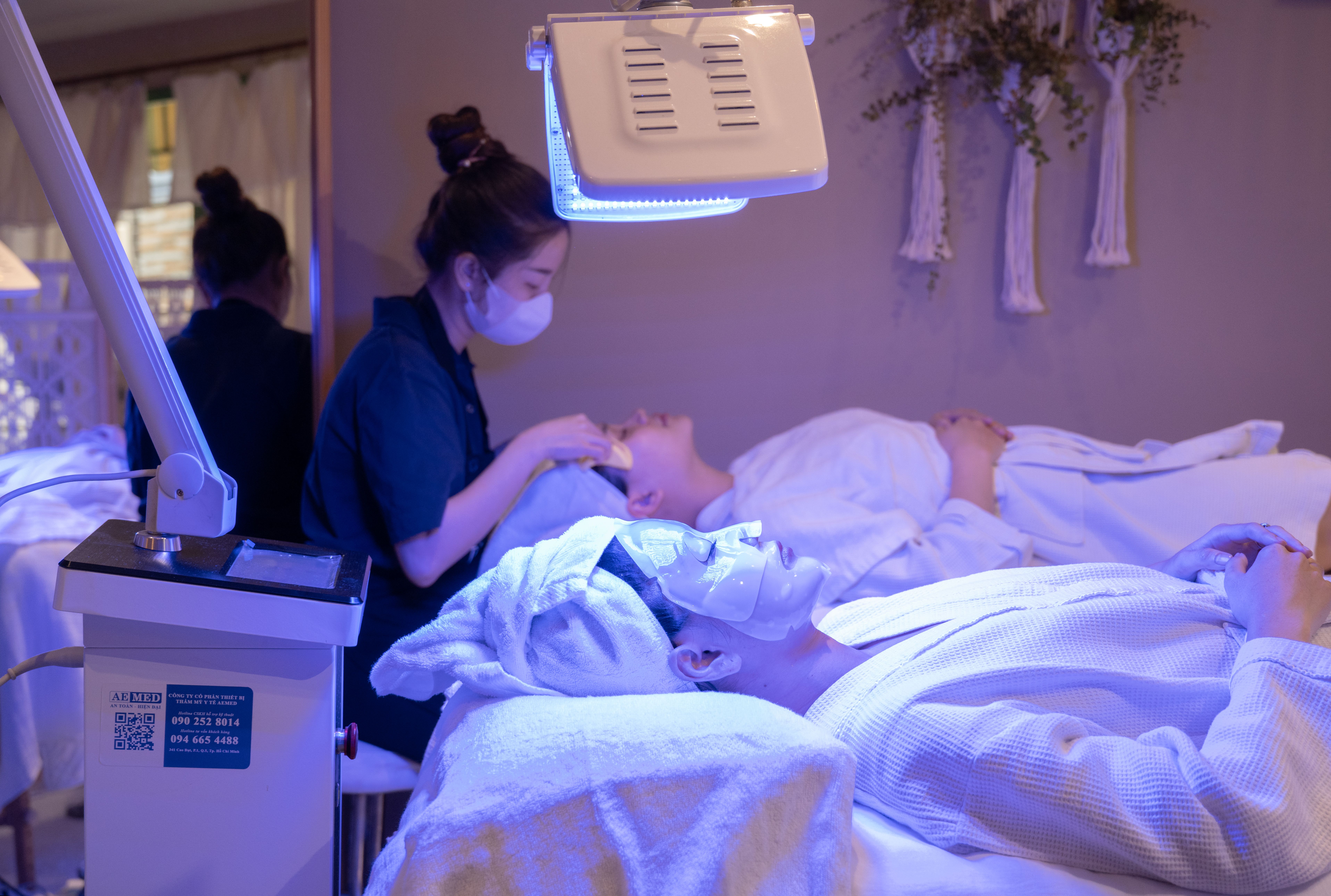 Free Patients receiving LED light therapy and facial treatment in a spa setting. Stock Photo
