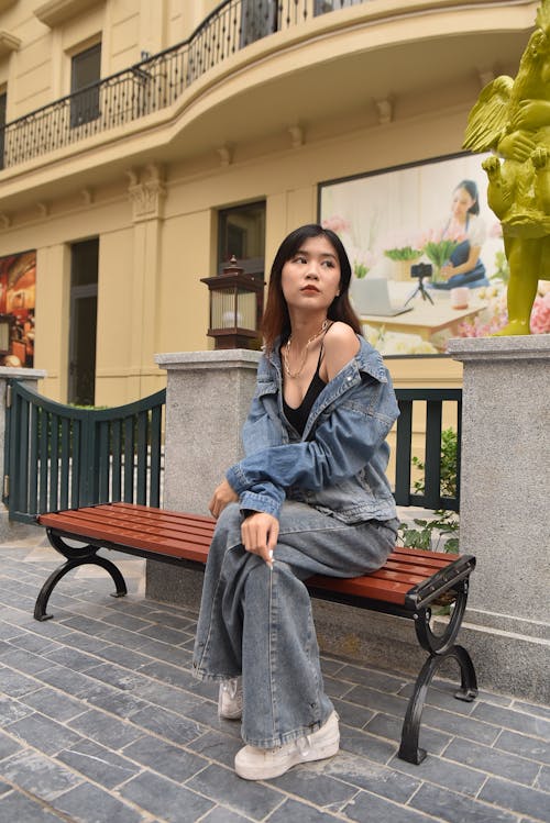 Young Woman in a Casual Outfit Sitting on a Bench