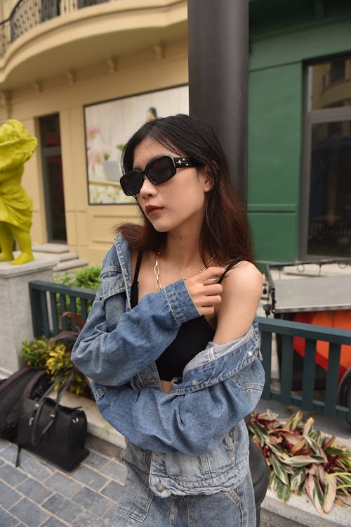 Young Woman in a Casual Outfit Standing in front of a Building in City 