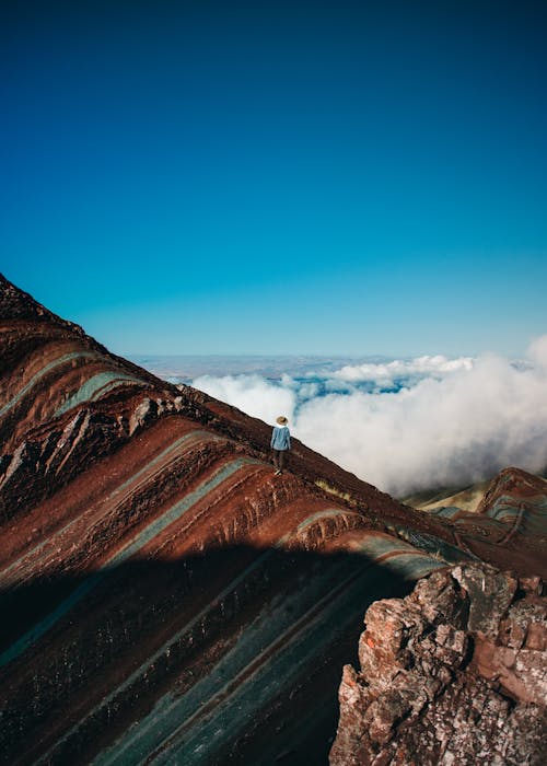 Person Standing on Barren Mountain Peak