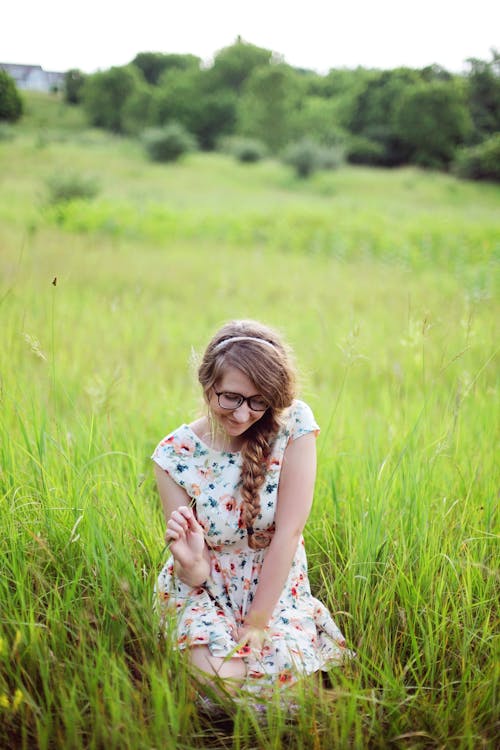 Woman Sitting on Grass Field