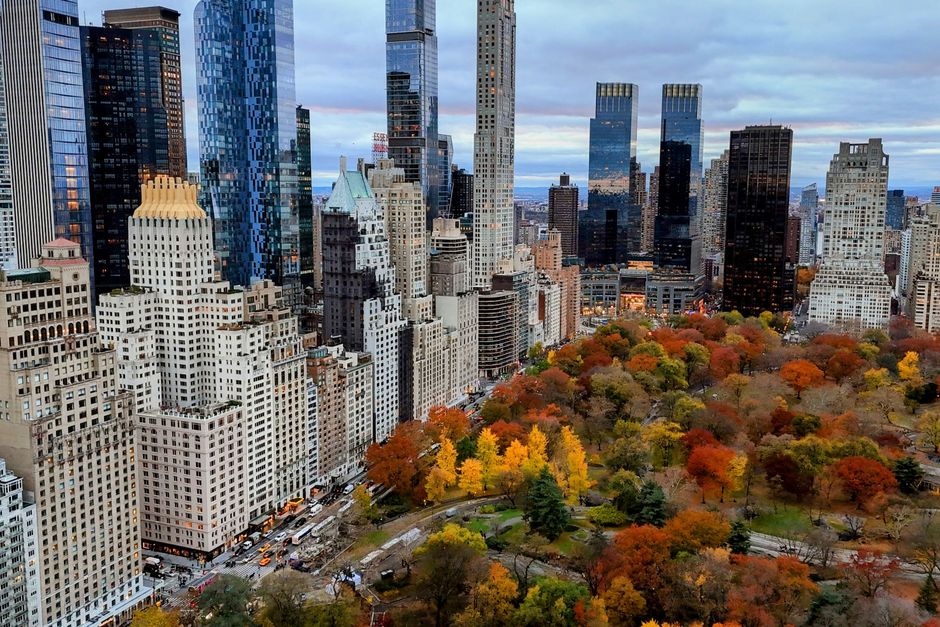 Aerial view of Central Park surrounded by New York City skyscrapers in vibrant fall colors