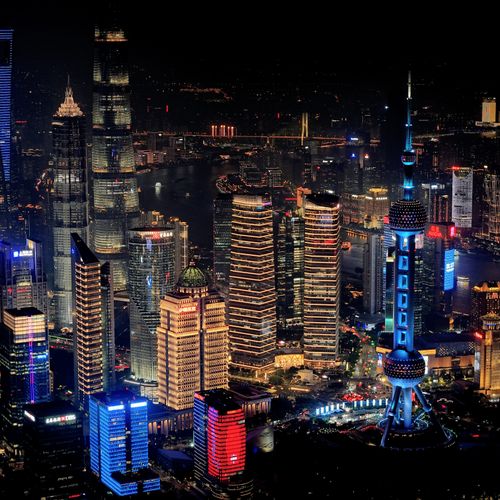 Free A stunning aerial view of Shanghai's cityscape at night featuring the illuminated Oriental Pearl Tower. Stock Photo