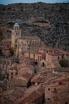 Scenic aerial view of Albarracin village with its iconic cathedral surrounded by rugged terrain in Spain.