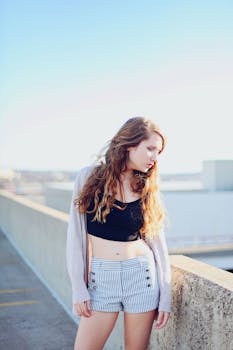 A fashionable young woman with long hair in an urban rooftop setting.