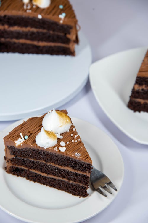 Close-up of Slices of Chocolate Layer Cake on White Plates 