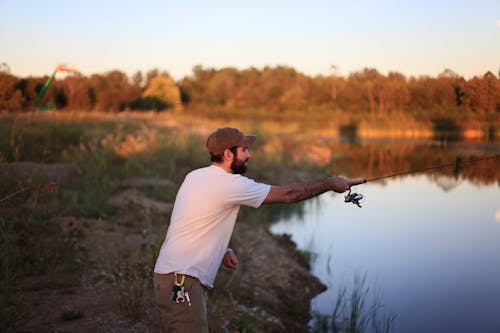 Uomo Che Pesca Sullo Stagno Vicino Al Campo Di Erba