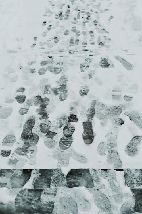 View of Footprints on the Snowy Sidewalk 