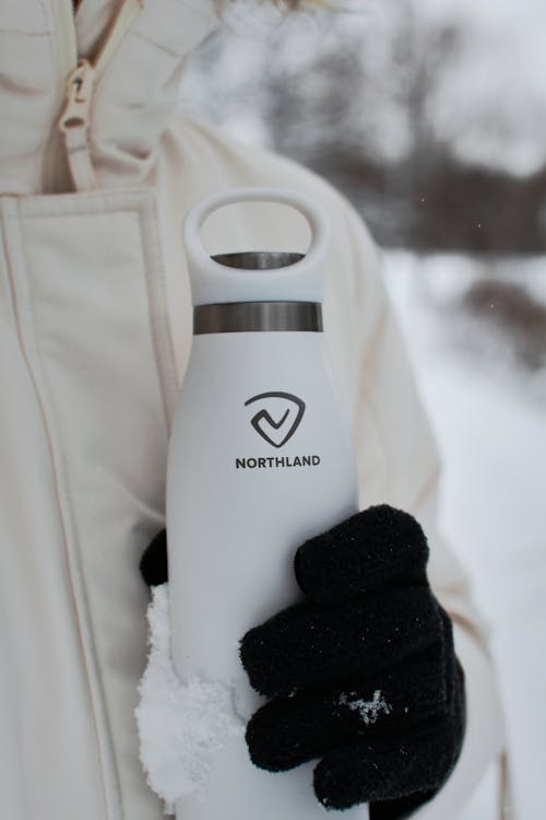 Close-up of Woman Wearing a Jacket and Gloves Holding a Thermos 