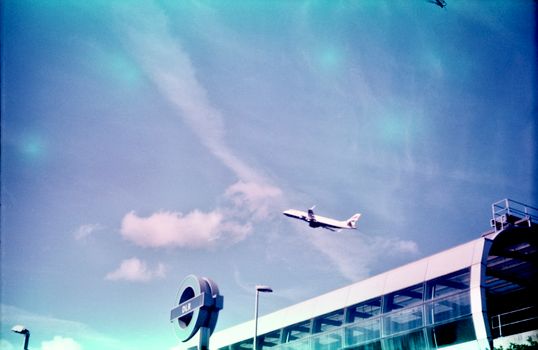 A plane flying over a building with a large window