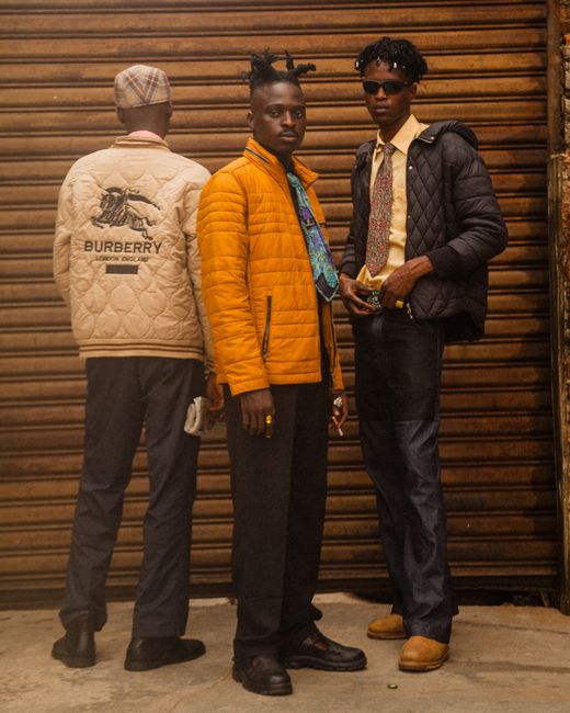 Stylish young men posing in urban setting with Burberry jackets and printed neckties.