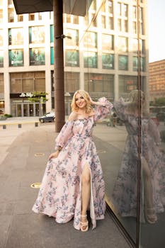 Fashionable woman in a floral dress posing in urban London, showcasing street style glamour.