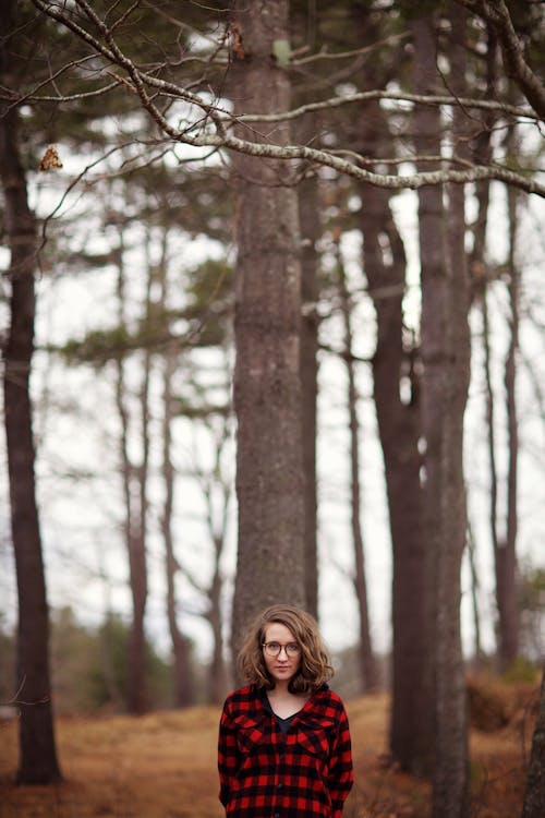 Женщина, стоящая в окружении деревьев