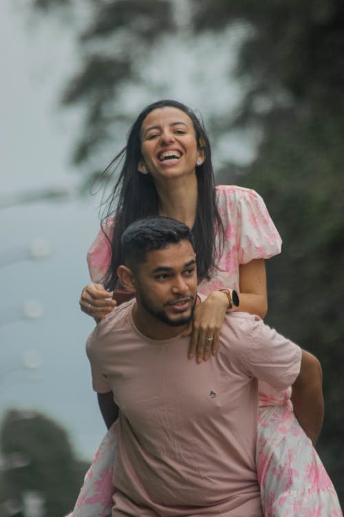Man Carrying Laughing Woman on Back