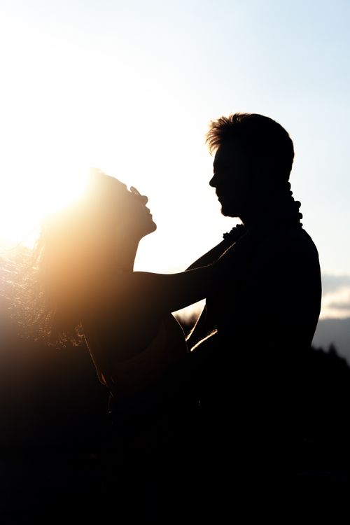 Free A romantic silhouette of a couple embracing against a warm sunset, capturing love and connection. Stock Photo
