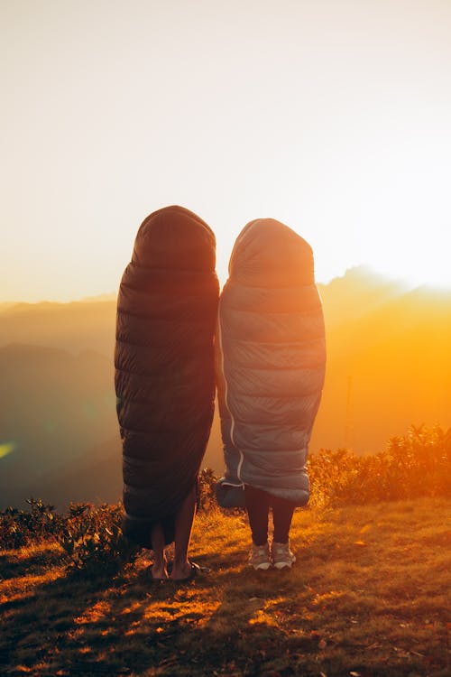 Two Women in Winter Coats Looking at Sunset 