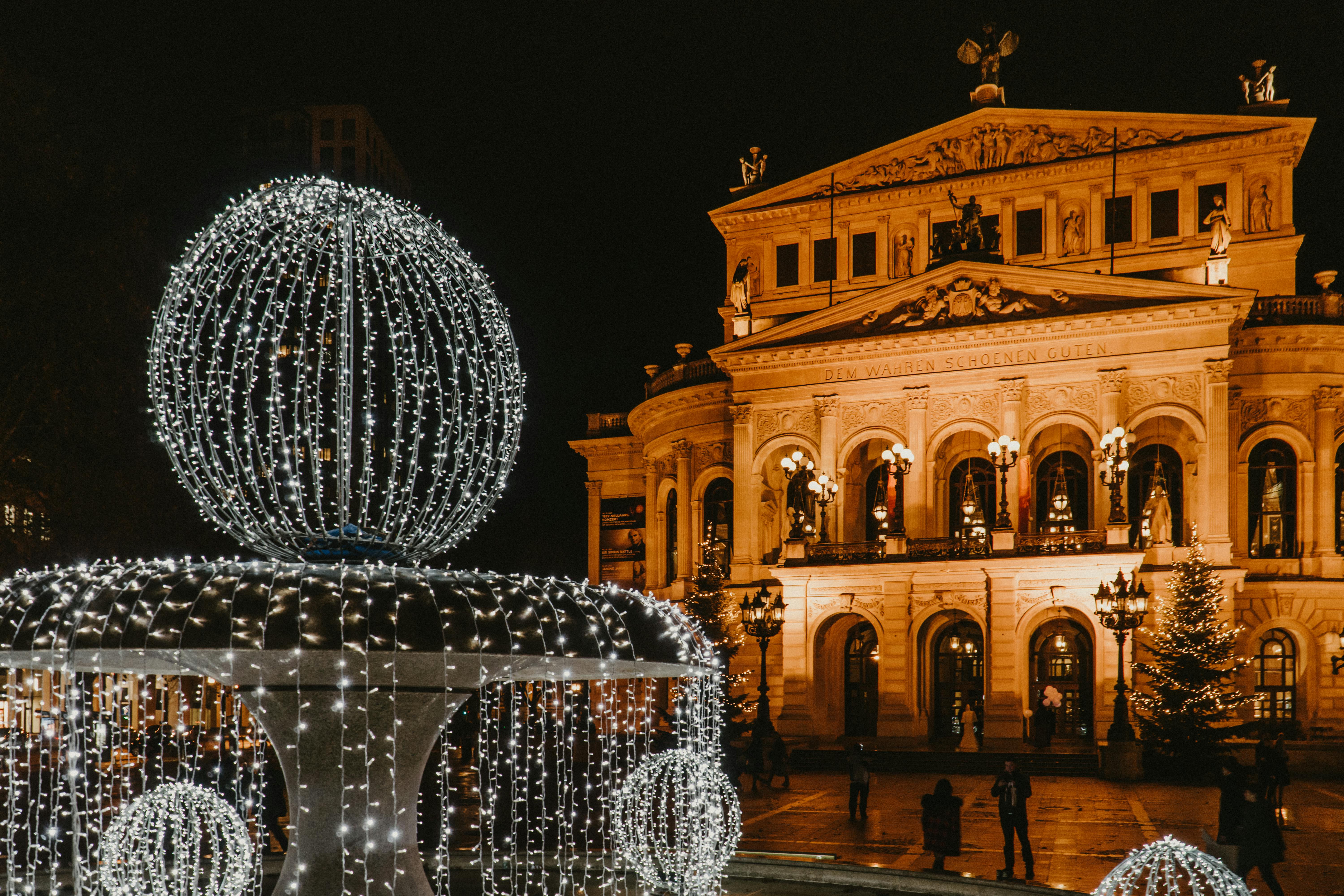 fountain decorated with christmas lights on the square in front of the frankfurt alte oper