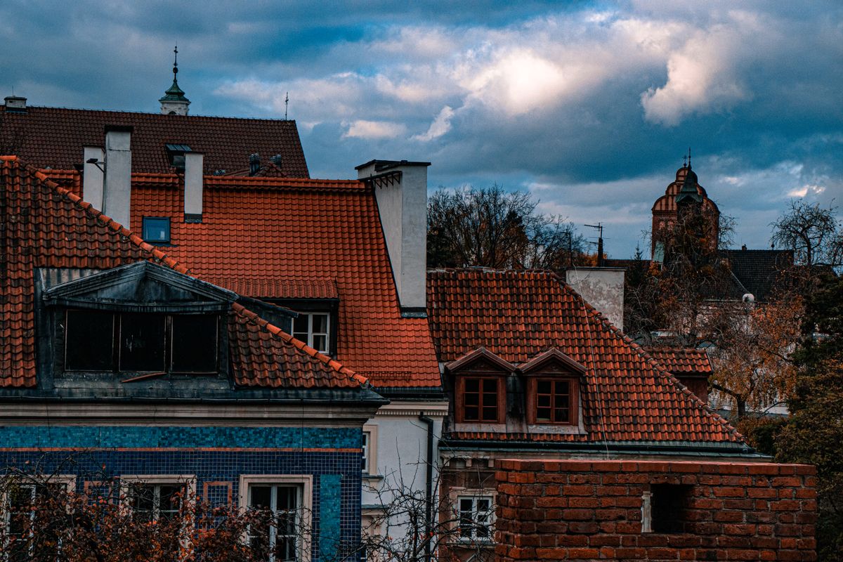 The red tiled roofs of the old town of Warsaw under a clear sky