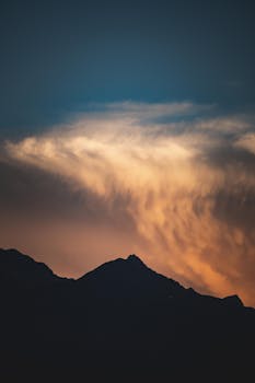 Breathtaking mountain silhouette against a vibrant, dramatic sunset sky.
