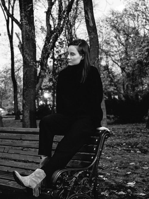 Woman Sitting on Bench at Park in Black and White