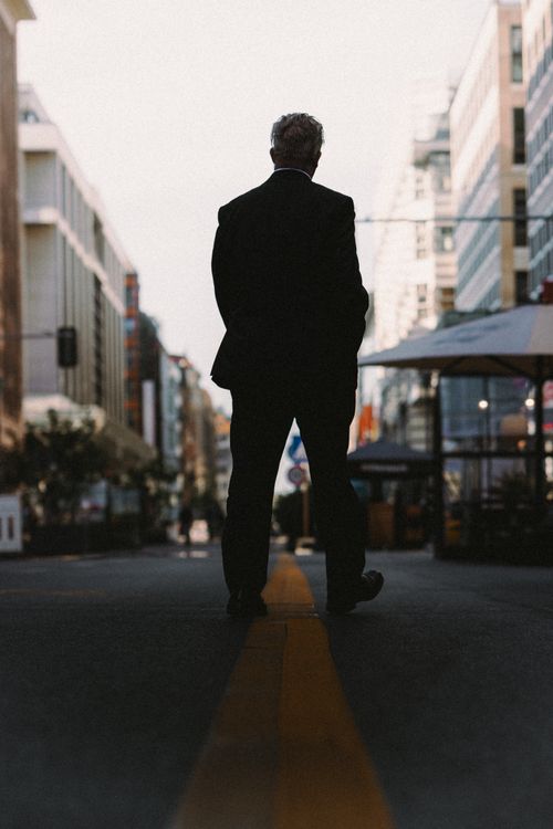 Free Silhouette of a man standing on a Berlin street, showcasing urban architecture. Stock Photo
