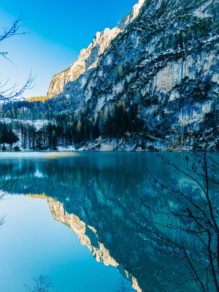 Mountain And Trees In Winter Reflected In A Lake