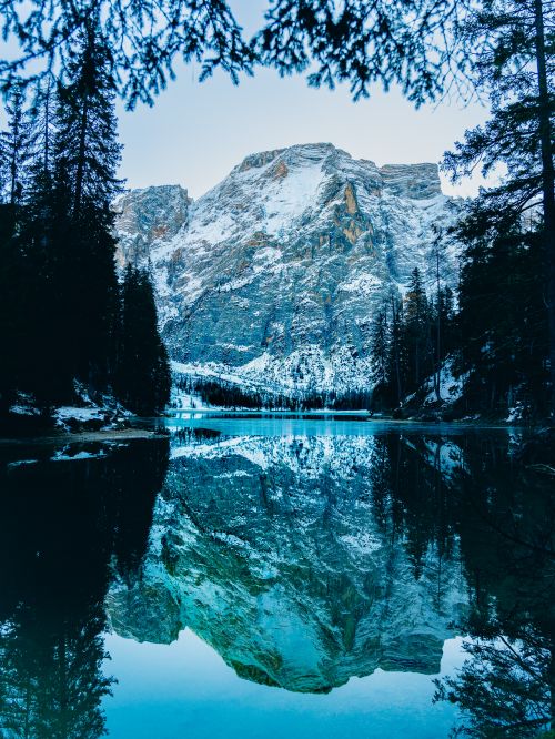 Free Stunning winter landscape with snow-capped mountains reflecting in a serene lake in Trentin-Haut-Adige, Italy. Stock Photo