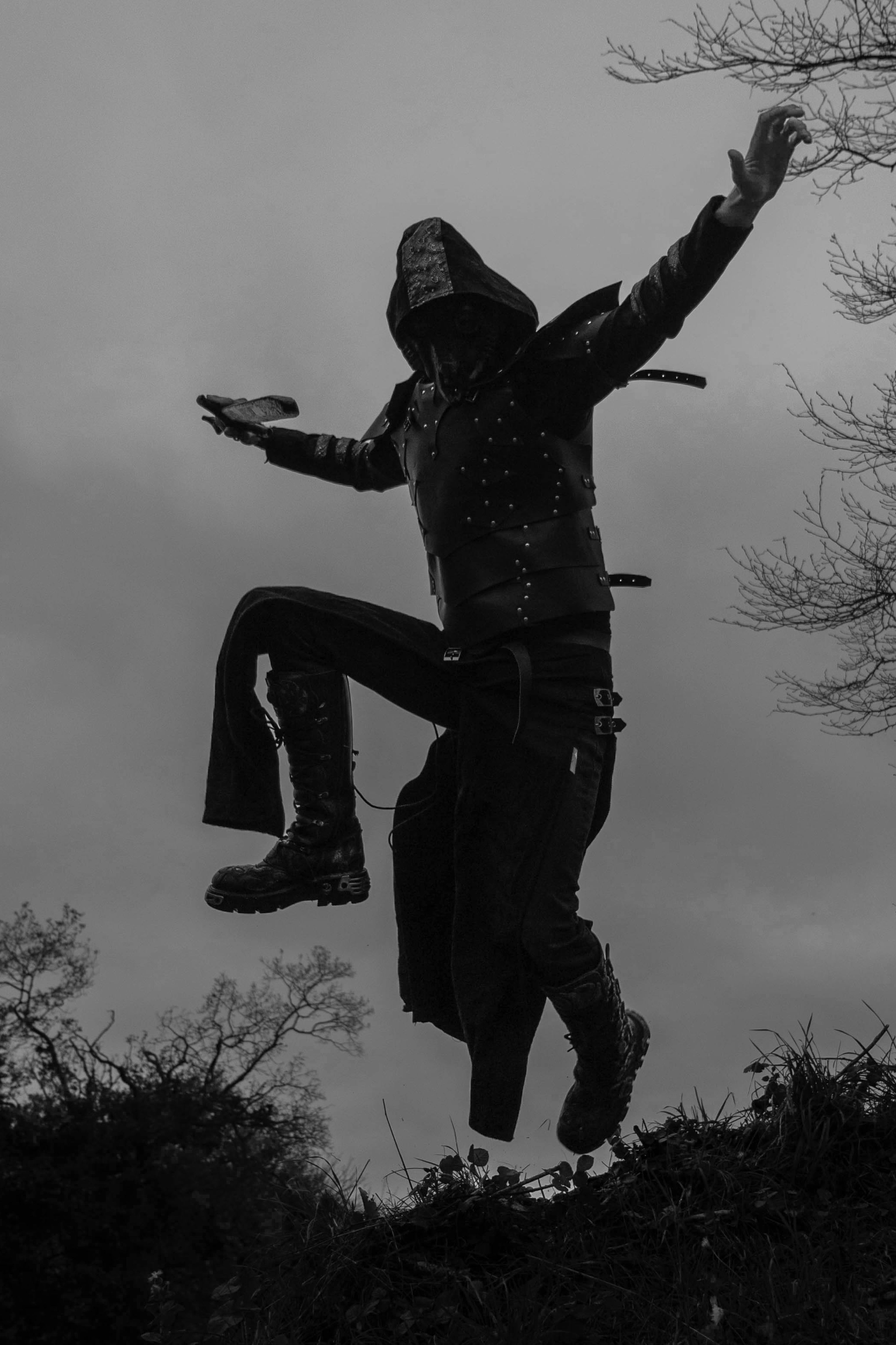 A dramatic silhouette of a cosplayer leaping outdoors in Bretagne, France.