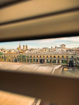 A unique view of Barcelona's historic skyline peeking through window blinds.