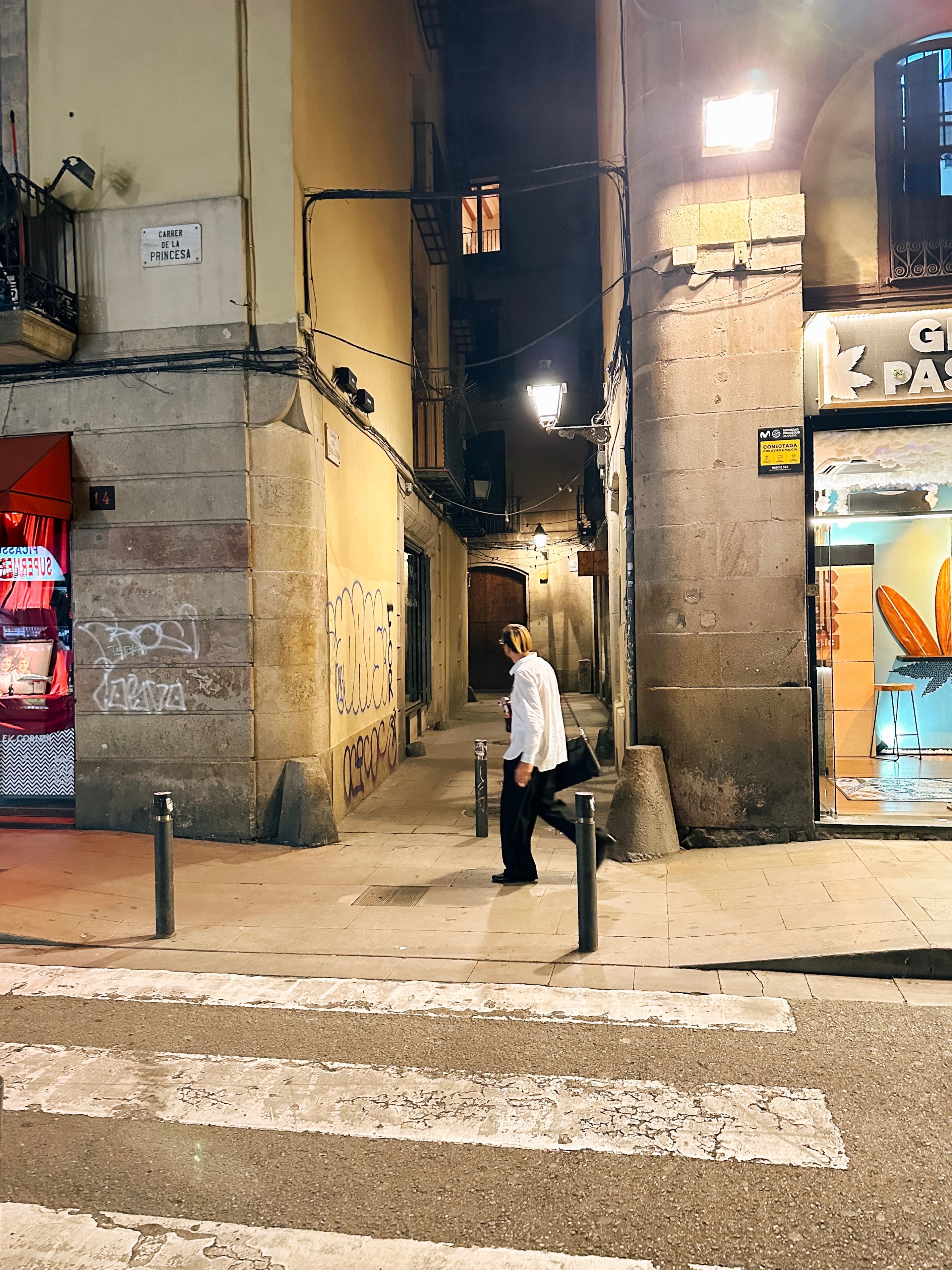 A person walking in a lively urban street at night in Barcelona, Spain, showcasing vibrant city life.