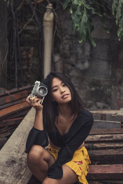 Woman Sitting On Stairs While Holding Black Dslr Camera