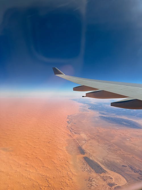 An Airplane Flying Above a Desert 