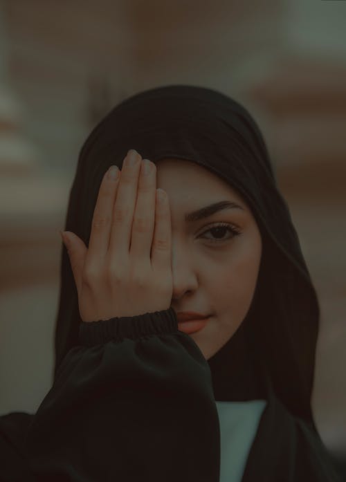 Dark Photo of a Young Muslim Woman Covering Her Eye